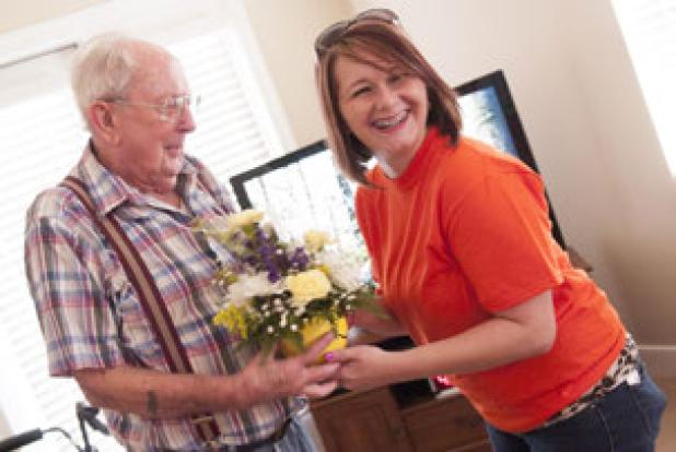 Brooke Schulze breaks into a smile as she presents Stoney Brook resident Asberry Stephens with a bouquet of flowers during the National Make Someone Smile week.