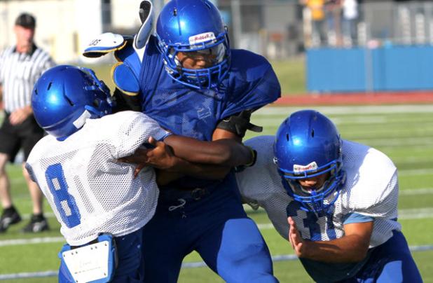 Copperas Cove running back Trent Canion is tackled by defenders Shamad Lomax (8) and Jace Leimbach during the Soap, Shampoo and Towel intrasquad scrimmage on Saturday at Bulldawg Stadium. The team will hit the road for their first scrimmage against another team.