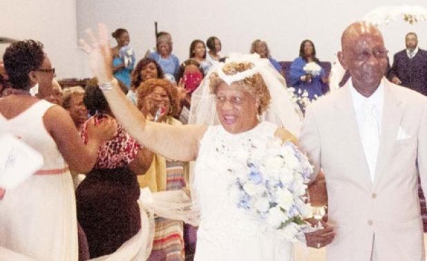 Christina waves to her family as she makes her way down the aisle with her husband, Leroy Lemmon.