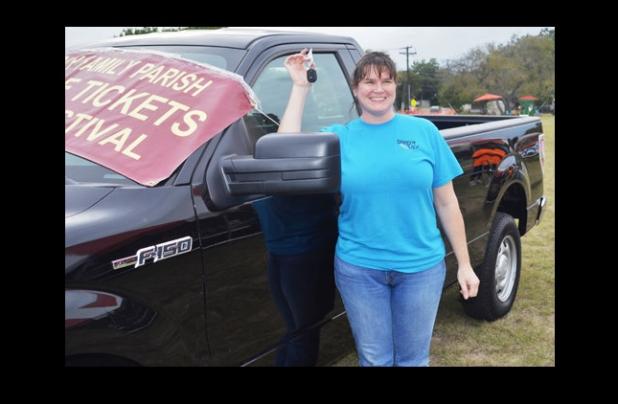 Malae Lucas holds the keys as she stands by the 2014 Ford F150 she won at Holy Family Catholic Church’s Fall Festival.