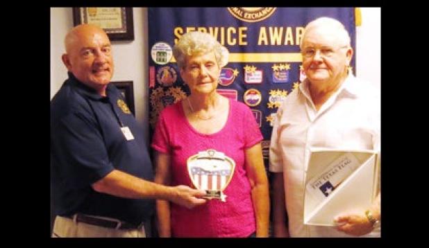 Mark Peterson, left, presents Francis and Rita Walker with the Proudly We Hail award for flying their flag.