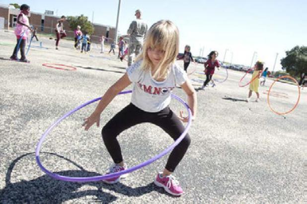 Martin Walker first grader Caitlyn Ervin spins her hoop as she participates in the Hot Chips and Hoops event Friday.