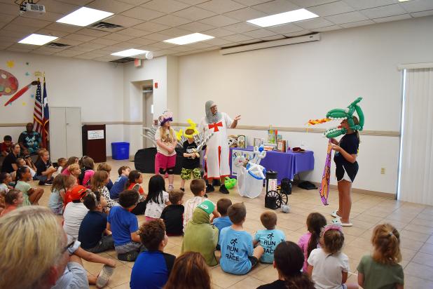 Volunteers don various balloon creations and show off their acting skills at Mr. Mark’s Twisty Art show, the Summer Reading Program’s final show for the season..