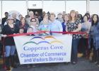 CCLP/LYNETTE SOWELL - Joann Courtland and Trudy Bolton with Operation Stand Down Central Texas cut the ribbon to the nonprofit’s newer, larger location in Cove Terrace Shopping Center on Saturday.