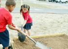 CCLP/LYNETTE SOWELL - Cove Charter Academy first grade students Nicholas Jeffries and Carmen Barragen add more dirt to planter beds at the campus’ garden area. The students are growing an organic garden and learning about rainwater harvesting.
