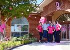 CCLP/LYNETTE SOWELL -- The staff at Clear Creek Meadows Apartments stand in front of their decorated entryway. The business was awarded first place in the Pink Out The Town contest held by Pink Warrior Angels.
