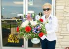 Trudy Bolton leaves A&L Florist on Wednesday morning with a flower arrangement donated by the shop for the funeral of Arthur McClanahan, an unaccompanied veteran who served in the Air Force from 1981-1983. 