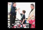 Joshua Garretson celebrates winning a new bike with high fives for members of the Rotary club and Wal-Mart.