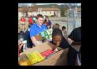 Students at Cove’s Priority Charter School load food they collected for My Brother’s House food pantry.