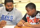 CCHS Coach Cecil Johnson tutors Bulldawg football player Darish Robinson in World Geography through the P.A.S.S. Club where more than 200 athletes come for assistance with their studies to boost their GPAs and keep them playing in the school’s sports programs.