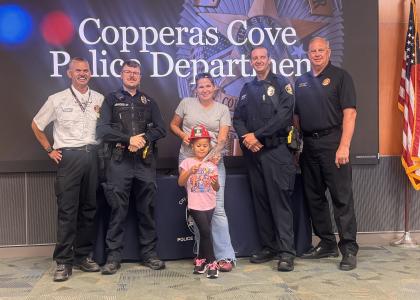 CCLP/LynetteSowell 5-year-old Casia Tucker and her mothere, Casey Gauman, receive challenge coins from both the Copperas Cove Police and Fire Departments for their quick actions to help put out a fire that broke out on the balcony of a nearby apartment on Aug. 2.