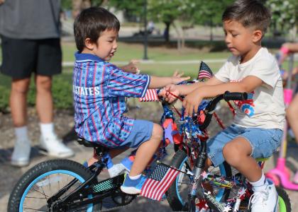 Tyler Hrometz, left, and Bentlee Lamb compare their bicycles, decorated in red, white and blue, before joining the Central Texas College Child Development Center Patriotic Parade celebrating America's 250th birthday.
